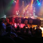a group of people on a stage with a band on stage