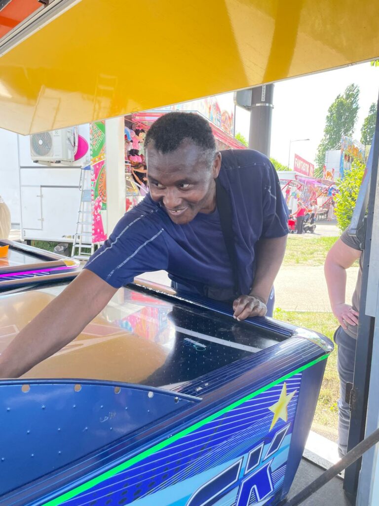 Personne accompagnée jouant à une activité de la fête foraine