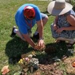photographie de deux personnes dont une touchant de fleur